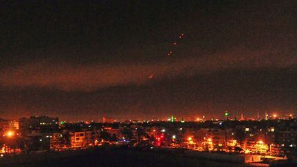 Sur cette image postée sur le site de l'Agence Arabe Syrienne Informations (Sana), dans la nuit du 14 avril 2018, les feux antiaériens dans la banlieue de Damas (Syrie) illuminent le ciel. (HANDOUT / STR / SANA)