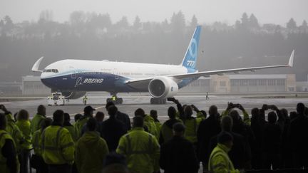 Le&nbsp;Boeing 777X devant les employés du constructeur aéronautique, lors de son vol inaugural, le 25 janvier 2020 à Seattle (Etats-Unis). (JASON REDMOND / AFP)