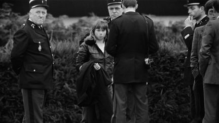 Agée de 15 ans, Murielle Bolle, témoin clé dans l'affaire Grégory, est entourée par les gendarmes le 7 novembre 1984 à Lépanges-sur-Vologne (Vosges). (JEAN-CLAUDE DELMAS / AFP)