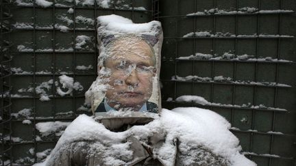 Un portrait de Vladimir Poutine utilisé comme cible par des soldats ukrainiens, le 21 janvier 2022 à Zolote (Ukraine). (ANATOLII STEPANOV / AFP)