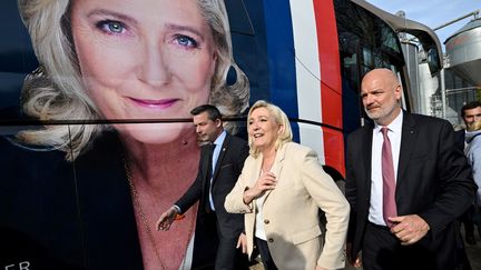 Marine Le Pen, devant un bus à son effigie, lors d'un déplacement électoral, le 11 avril 2022. (LUDOVIC MARIN / AFP)