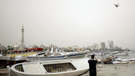 Un hélicoptère de l'armée libanaise survole le port de Tripoli, au lendemain du naufrage d'un bateau e migrants au large de la ville , le 24 avril 2022. (IBRAHIM CHALHOUB / AFP)