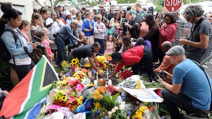 Drapeaux, bougies et bouquets de fleurs sont amen&eacute;s pour rendre hommage &agrave; Nelson Mandela, jeudi 6 d&eacute;cembre. Les gens se sont regroup&eacute;s devant la maison de l'ancien pr&eacute;sident &agrave; Johannesbourg.&nbsp; (STEPHANE DE SAKUTIN / AFP)