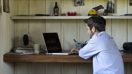 Un homme travaille sur son ordinateur portable. (FREDERIC CIROU / MAXPPP)