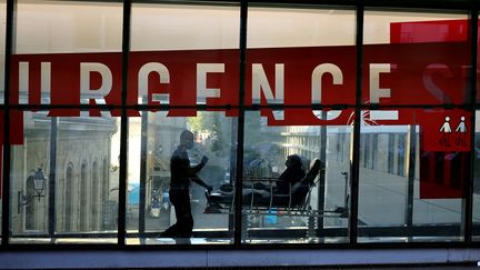 Un patient emmène&nbsp;un patient dans un couloir du service des urgences de l'hôpital Tenon à Paris, le 23 septembre 2021. (THOMAS COEX / AFP)