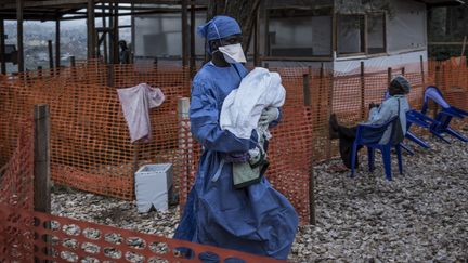 Un medecin avec un bébé dans les bras, peut-être infecté par le virus Ebola à&nbsp; Butembo, en République Démocratique du Congo, le 4 novembre 2018.&nbsp; (JOHN WESSELS/AFP)