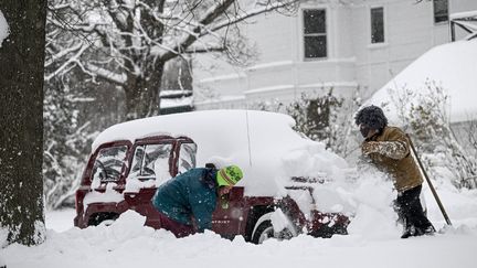 Des habitants de Buffalo (New York) déblayent leur voiture recouverte de neige, le 26 décembre 2022. (FATIH AKTAS / ANADOLU AGENCY / AFP)