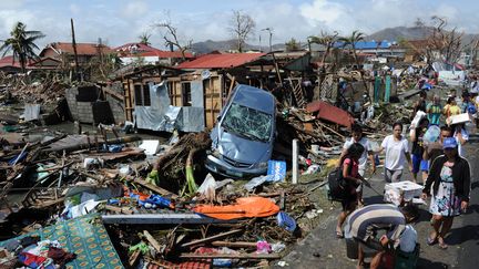 Des habitants marchant le long de rues d&eacute;vast&eacute;es par le typhon Haiyan, &agrave; Tacloban (Philippines), le 10 novembre 2013. (TED ALJIBE / AFP)