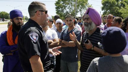 La police et les fid&egrave;les du temple sikh apr&egrave;s la fusillade &agrave; Oak Creek (Wisconsin, Etats-Unis), le 5 ao&ucirc;t 2012.&nbsp; (ALLEN FREDRICKSON / REUTERS / X00101)