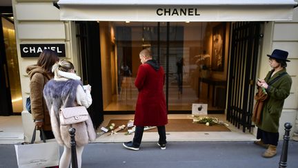 Des admirateurs de Karl Lagerfeld déposent des roses blanches devant le siège de la maison de couture Chanel, mardi 19 février 2019. (LIONEL BONAVENTURE / AFP)