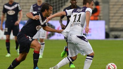 Marc Planus (Bordeaux) tente de retenir Aleksander Pesic (Toulouse) (MEHDI FEDOUACH / AFP)