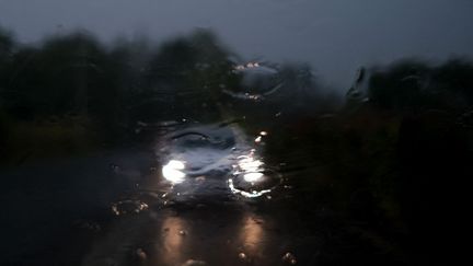 Une voiture sous une pluie d'orage, à Béziers (Hérault), le 22 août 2019. (LAURENT FERRIERE / HANS LUCAS / AFP)