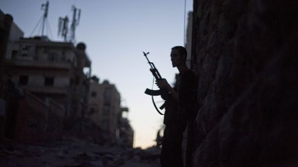 Un combattant de l'Arm&eacute;e syrienne libre (ASL) tient son arme durant de violents affrontements &agrave; Alep, en Syrie, le 9 septembre 2012. (ZAC BAILLIE / AFP)