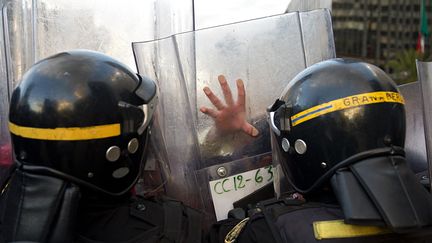 Des policiers anti-&eacute;meutes repoussent des manifestants contre la r&eacute;forme de l'&eacute;ducation &agrave; Mexico (Mexique), le 26 novembre 2013. (YURI CORTEZ / AFP)