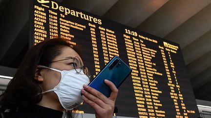 Un passager muni d'un masque à l'aéroport de Rome (Italie). Photo d'illustration. (TIZIANA FABI / AFP)