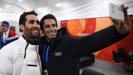 Le champion olympique de biathlon Martin Fourcade et Tony Estanguet, le président du Comité d'organisation des JO de Paris, à Pyeongchang, le 19 février. (FRANCK FIFE / AFP)