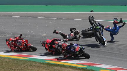 Fabio Quartararo en tête&nbsp;tandis que Francesco Bagnaia, Alex Rins et Takaaki Nakagami chutent, lors du Grand Prix de Catalogne, le 5 juin 2022 à Barcelone. (LLUIS GENE / AFP)