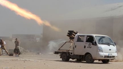 Des miliciens chiites irakiens tirent des roquettes sur des positions de combattants de l'Etat islamique, le 3 septembre 2014, pr&egrave;s de Tikrit (Irak). (AHMAD AL-RUBAYE / AFP)