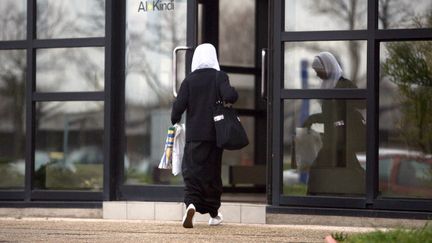 Une femme voil&eacute;e entre dans un b&acirc;timent scolaire &agrave; Lyon (Rh&ocirc;ne), en 2007. (FRED DUFOUR / AFP)