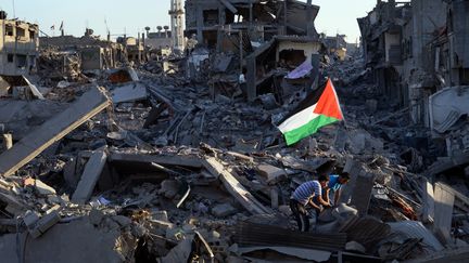 Des Palestiniens dans les d&eacute;combres &agrave; Gaza, le 7 ao&ucirc;t 2014. (ROBERTO SCHMIDT / AFP)