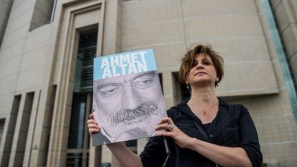 Une journaliste turque pose avec une photo d'Ahmet Altan devant le Palais de Justice d'Istanbul (février 2018)
 (OZAN KOSE / AFP)