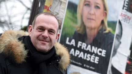 Steeve Briois pose devant une affiche de campagne de Marine Le Pen, le 30 janvier 2017, à Hénin-Beaumont (Pas-de-Calais). (FRANCOIS LO PRESTI / AFP)