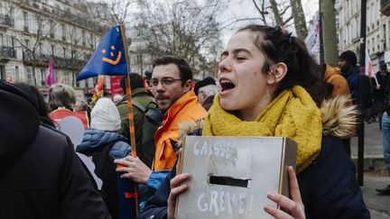 Une manifestante avec une caisse de grève à Paris, le 11 mars 2023. (MAXPPP)