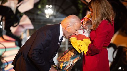 Joe Biden s'est amusé à faire semblant de croquer cet enfant déguisé en poulet lors d'une cérémonie pour Halloween, le 30 octobre 2024. (TIERNEY CROSS / AFP)