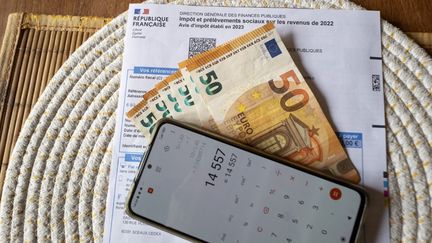 Billets de cinquante euros étalés sur un avis d'impôt sur le revenu 2023, 11 avril 2024. (SERGE TENANI / HANS LUCAS / AFP)