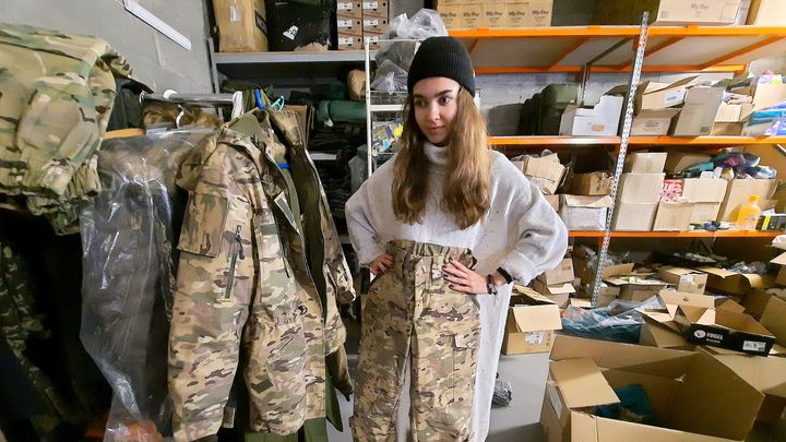 Ksenia, à la tête de l'association Zemliachky, qui équipe les femmes soldats. Elle pose avec l'uniforme qu'elle fait faire pour envoyer aux femmes soldats. (AGATHE MAHUET / RADIO FRANCE)