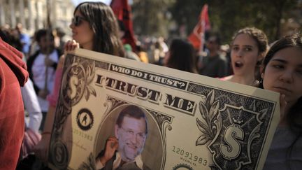 Des manifestants anti-aust&eacute;rit&eacute; brandissent un billet de un dollar &agrave; l'effigie de Mariano Rajoy, le Premier ministre espagnol, &agrave; Madrid, le 11 mars 2012. (PEDRO ARMESTRE / AFP)