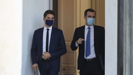 Gabriel Attal, porte-parole du gouvernement (à gauche) et Olivier Véran, ministre des Solidarités et de la Santé (à droite) à la sortie du conseil des ministres, le 14 octobre 2020. (S?BASTIEN MUYLAERT / MAXPPP)