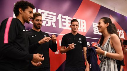 Des joueurs&nbsp;du Paris Saint-Germain signent des autographes pour les fans chinois avant une séance d'entraînement à Shenzhen, le 2 août 2018. (ANNE-CHRISTINE POUJOULAT / AFP)