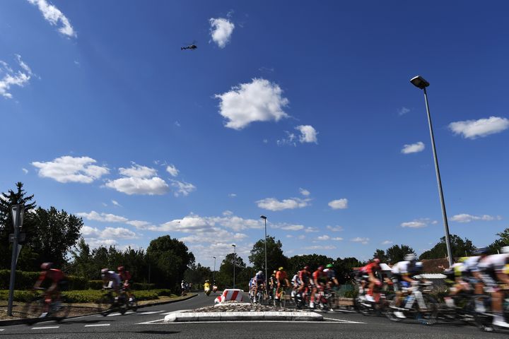 Le peloton se scinde en deux pour franchir un rond-point lors de l'étape entre Saint-Flour (Cantal) et Albi (Tarn), le 15 juillet 2019. (JEFF PACHOUD / AFP)