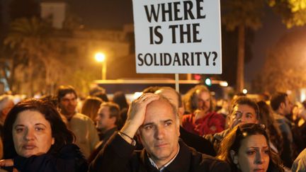 Des employ&eacute;s de la Popular Bank (Laiki en grec), l'une des deux grandes banques chypriotes menac&eacute;es,&nbsp;manifestent jeudi 21 mars devant le Parlement&nbsp;&agrave; Nicosie (Chypre). (PATRICK BAZ / AFP)