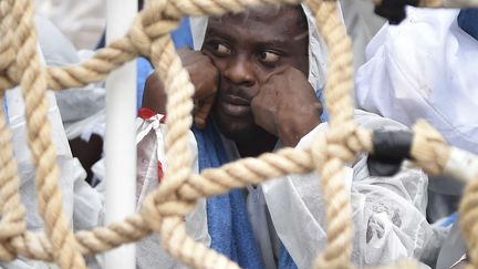 Quelques jours plus tard, ce migrant s'abrite de la pluie en attendant d'&ecirc;tre d&eacute;barqu&eacute; du bateau des gardes-c&ocirc;tes italiens de Messine en Sicile le 4 ao&ucirc;t 2015.&nbsp; (CARMELO IMBESI/AP/SIPA / AP)