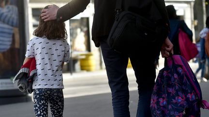 Un parent à la sortie de l'école avec son enfant, le 1er avril 2021 à Saint-Etienne. (R?MY PERRIN / MAXPPP)