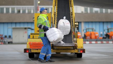 Un homme charge un avion en produits humanitaires, destin&eacute;s aux survivants du typhon Haiyan aux Philippines, le 10 novembre 2013, &agrave; l'a&eacute;roport de Francfort (Allemagne). (FREDRIK VON ERICHSEN / DPA)