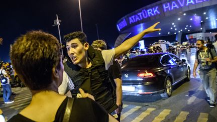 Un officier de police dirige une passagère à l'aéroport international Ataturk, le 28 juin 2016, après les attentats perpétrés par des kamikazes. (OZAN KOSE / AFP)