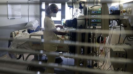 Une soignante s'occupe d'un patient atteint du Covid-19 dans le service de réanimation de l'hôpital de Saint-Pierre, à La Réunion, le 30 juillet 2021. (RICHARD BOUHET / AFP)