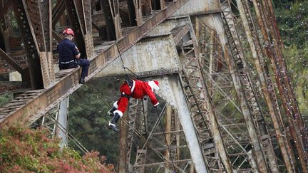 Cette distribution prend une tournure plus chaotique &agrave; Guatemala City (Guatemala), o&ugrave; des pompiers distribuent des cadeaux aux enfants pauvres vivant dans des coins escarp&eacute;s, le 23 d&eacute;cembre 2012. (JORGE LOPEZ / REUTERS)