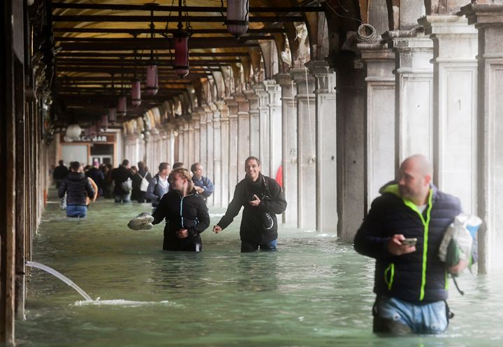 Des touristes sous une arche inondée à Venise en Italie, le 29 octobre 2018. (MIGUEL MEDINA / AFP)