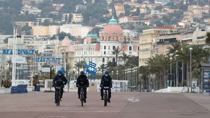 Des agents de police patrouillent sur l'emblématique Promenade des Anglais, samedi 27 février 2021, alors qu'un confinement entre en vigueur le week-end dans la ville de Nice (Alpes-Maritimes). (VALERY HACHE / AFP)