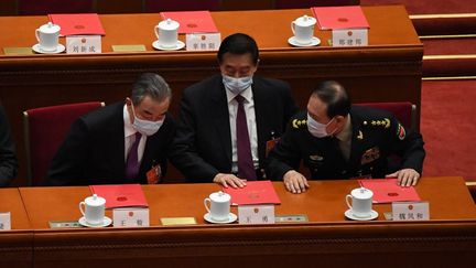 Le ministre chinois des Affaires étrangères, Wang Yi (à gauche), s'entretient avec le ministre chinois de la Défense, Wei Fenghe (à droite), à l'Assemblée populaire nationale, à Pékin, le 11 mars 2022. (LEO RAMIREZ / AFP)