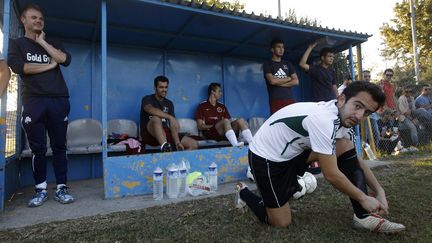 Giannis Baziolas, joueur et pr&eacute;sident du club de Voukefalas, se pr&eacute;pare &agrave; entrer sur le terrain, &agrave; Larissa (Gr&egrave;ce), le 20 octobre 2012. Son &eacute;quipe est&nbsp;devenue c&eacute;l&egrave;bre pour s'&ecirc;tre fait sponsoriser par une maison close locale et l'entreprise de pompes fun&egrave;bres du coin. (JOHN KOLESIDIS / REUTERS)