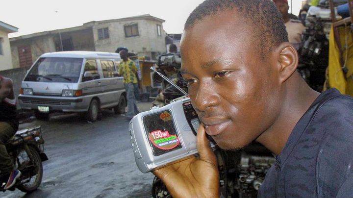 Un supporter nig&eacute;rian &eacute;coute un match de l'&eacute;quipe nationale pendant la Coupe du monde 2002 dans les rues de Lagos, la capitale, le 12 juin 2002. (PIUS UTOMI EKPEI / AFP)