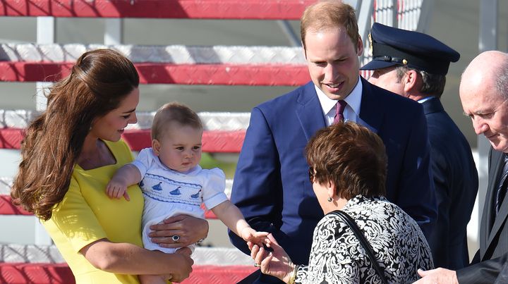 L'&eacute;pouse du gouverneur g&eacute;n&eacute;ral d'Australie touche la main du prince George, le 16 avril 2014 &agrave; l'a&eacute;roport de Sydney (Australie). (WILLIAM WEST / AFP)