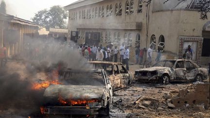 Un v&eacute;hicule en feu pr&egrave;s de l'&eacute;glise catholique de Madalla, dans la banlieue d'Abuja, au Nigeria, le 25 d&eacute;cembre 2011. (AFOLABI SOTUNDE / REUTERS)