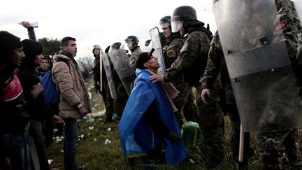 26 novembre 2015. Près d’Idomeni, à la frontière gréco-macédonienne, un migrant s’agenouille devant des policiers macédoniens après avoir franchi la frontière grecque. La Macédoine, comme de nombreux pays européens, a imposé des restrictions au passage de sa frontière. La foule criait aux policiers «Ouvrez la frontière !» (ANGELOS TZORTZINIS / AFP)