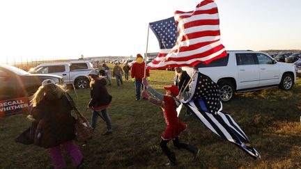 Une supportrice de Donald Trump brandit un drapeau lors d'un meeting à Grand Rapids, Michigan, dans le Michigan. (JEFF KOWALSKY / AFP)